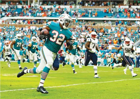  ?? Kenyan Drake storms into the end zone to seal a remarkable last-gasp win for the Miami Dolphins against the highly fancied New England Patriots. ??