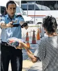  ??  ?? Tension on the streets of Ankara as a policeman points his gun at a passerby