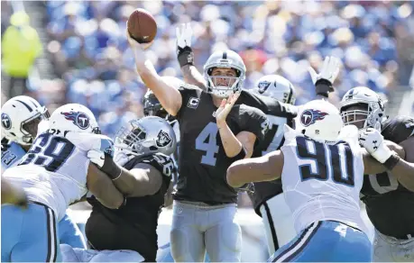  ?? WESLEY HITT/GETTY IMAGES ?? The Raiders’ Derek Carr gets off a pass under pressure against the Titans. Carr threw for 249 yards and a touchdown in the win against Tennessee.