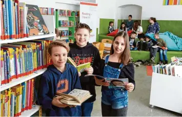  ??  ?? Hier, in der St. Georg Volksschul­e, entstand 2010 die erste Leseinsel – nun wurde dort Bilanz gezogen. Mittlerwei­le haben zehn Schulen in Augsburg die modernen Büchereien. Luis (11), Andreas (11) und Sandra (11) (von links) schauen in die Bücher der...