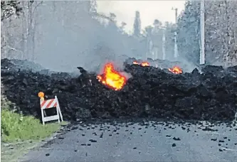  ?? HAWAII ELECTRIC LIGHT THE ASSOCIATED PRESS ?? Lava flows over a road near Pahoa on the Big Island of Hawaii on Friday.