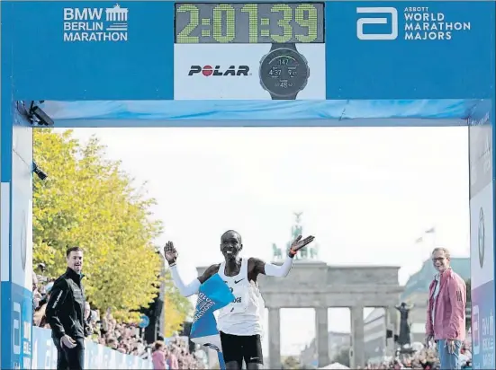  ?? MARKUS SCHREIBER / AP ?? Una marca para la historia: Eliud Kipchoge, en el momento de cruzar la línea de meta el pasado domingo en Berlín