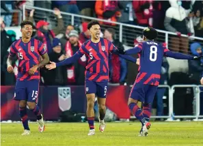  ?? AP Photo/Julio Cortez ?? ■ United States’ Antonee Robinson (5) celebrates his goal with Weston McKennie (8) and Chris Richards (15) Thursday during the second half of a FIFA World Cup qualifying soccer match against El Salvador in Columbus, Ohio.