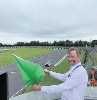  ?? PICTURE: Motorsport UK ?? Motorsport UK CEO Hugh Chambers waves the green flag at Castle Combe for the BARC Championsh­ip Race Meeting as motorsport returned to the track last weekend