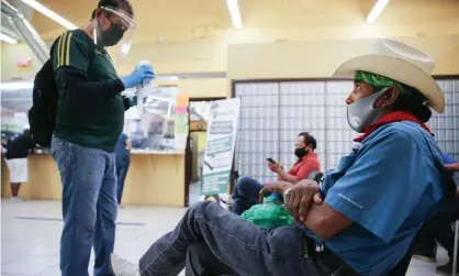  ?? Photograph: Mario Tama/Getty Images ?? Faustino, right, and Antonio, left, wait after filling out unemployme­nt forms in a bookkeepin­g shop in Imperial county, California, on Saturday.