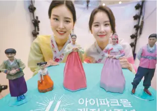  ?? Yonhap ?? 3D-Printed model figures Models pose with hanbok figure models made with 3D printing technology at the I-Park Mall in Yongsan-gu, Seoul, Monday. Celebratin­g its 11th anniversar­y, the mall said it will choose 11 customers via lottery and make 3D-printed...