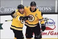  ?? Winslow Townson / Associated Press ?? The Boston Bruins’ Patrice Bergeron, right, celebrates with Brad Marchand, left, after Marchand scored against the Pittsburgh Penguins during the second period on Saturday in Boston.