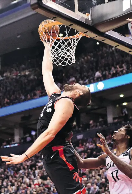  ?? FRANK GUNN / THE CANADIAN PRESS ?? Toronto’s Marc Gasol makes a reverse dunk Monday night with Brooklyn forward Ed Davis nearby.