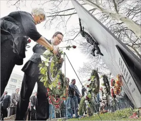  ?? HAMILTON SPECTATOR FILE PHOTO ?? Shelley Thrones and Lorne Newick of the Internatio­nal Brotherhoo­d of Electrical Workers Local 105 lay a wreath at the base of the fallen worker memorial outside Hamilton city hall during last year’s Day of Mourning to remember workers who have been...