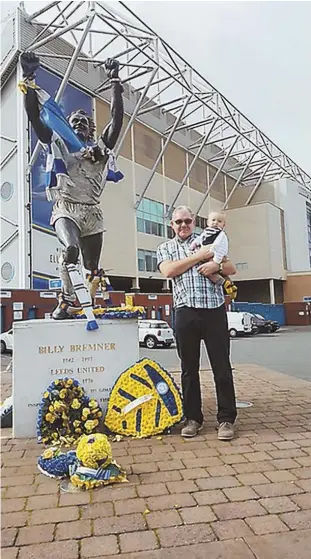  ?? PHOTO COURTESY ANDREW BUTTERWICK ?? SUPERFAN: Andrew Butterwick holds his grandson outside Elland Road stadium where his beloved soccer team Leeds United plays.