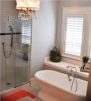  ??  ?? The master bedroom has casual look and feel with beadboard walls and pine floors. The master bathroom features a soaking tub and a projected window, which extends beyond the exterior wall of the house.The design makes the room look bigger and creates a...