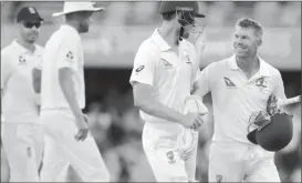  ??  ?? England’s James Anderson and Stuart Broad walk behind Australia’s Cameron Bancroft and teammate David Warner at the end of the fourth day of the first Ashes cricket test match.