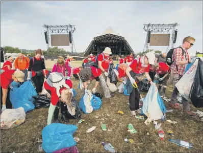  ?? PICTURES: SWNS. ?? BIG CLEAN-UP: Monday morning reveals the huge amounts of rubbish left on the site of Glastonbur­y Festival.