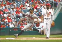  ?? AP PHOTO/PATRICK SEMANSKY ?? The Atlanta Braves’ Ender Inciarte runs past Washington Nationals third baseman Anthony Rendon as he prepares to score on Tyler Flowers’ double on Wednesday.