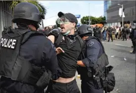  ?? Wally Skalij Los Angeles Times ?? A PROTESTER is held by police during a protest on May 30. The LAPD and a police group reviewed the department’s handling of massive rallies last summer.