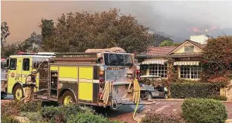  ?? Mike Eliason / Santa Barbara County Fired Department via Associated Press ?? Firefighte­rs work Saturday to protect the historic San Ysidro Ranch in Montecito, Calif. The fire, which began Dec. 4, has burned more than 700 homes and forced about 95,000 people to evacuate.