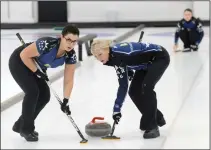  ?? NEWS PHOTO RYAN MCCRACKEN ?? Karlee Korchinski (left) and Natalie Yanko, of Team Fesser, sweep in the sixth end of Sunday’s Hat Charity Classic bonspiel women’s championsh­ip against Team Marthaller at the Medicine Hat Curling Club.