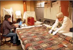  ??  ?? Volunteer master weavers Marty Benson, left, and Laura Redford conduct an in-depth study of 26 coverlets in the collection at the Shiloh Museum of Ozark History in Springdale.