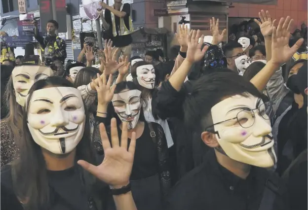  ??  ?? 0 Pro-democracy supporters defy a government ban on wearing masks and face coverings in public, which has been in place since October and not enforced by the police