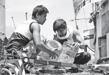  ?? BING GONZALES ?? NEIGHBORS volunteer to refill water in the mini fire truck that responded to a fire that hit Isla Verde in Barangay 23-C, Poblacion District on Friday afternoon.