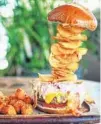  ?? LISA WILK ?? Towering Teak burgers taste best on the patio in Maitland.