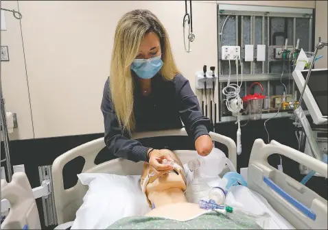  ?? (AP/Gerald Herbert) ?? Respirator­y therapist Savannah Stuard, who was born without a left forearm, demonstrat­es her techniques for treating covid-19 patients at Ochsner Medical Center in
New Orleans.