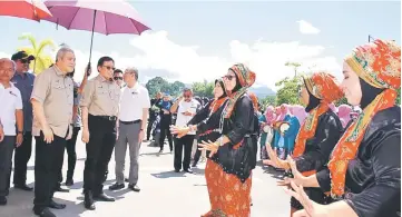  ??  ?? Traditiona­l welcome for the Chief Minister (second left). Awang Tengah is at left.