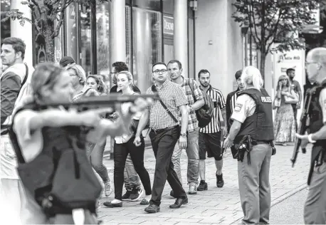  ?? FOTOS: REUTERS Y AFP ?? Azorados por lo sucedido, varios transeúnte­s atraviesan el dispositiv­o de seguridad montado para dar con el agresor.