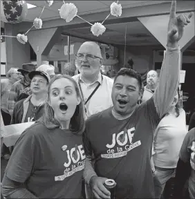  ?? PETER HUOPPI/THE DAY ?? Rep. Joe de la Cruz, right, reacts with campaign volunteer Margaret Twitty of Groton, left, as results are posted at Groton Democratic headquarte­rs on Tuesday.