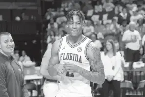  ?? MATT STAMEY/AP ?? Florida forward Keyontae Johnson, center, smiles after being introduced as a ceremonial starter before a game against Kentucky on March 5. The Norfolk native hasn’t practiced or played since his collapse in December 2020.