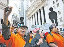  ?? MARK LENNIHAN/AP ?? Protesters march Tuesday in front of the New York Stock Exchange in New York. Activists around the country focused on labor issues, U.S. policies and voting issues on May Day.