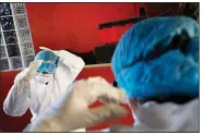  ?? (AP/Rebecca Blackwell) ?? Doctors Delia Caudillo (left) and Monserrat Castaneda put on protective gear Thursday as they prepare to conduct a covid-19 test at a home in the Venustiano Carranza borough of Mexico City.