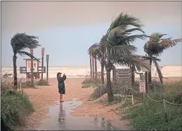  ??  ?? A woman on Cocoa Beach, Florida on Friday as Hurricane Dorian hits