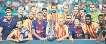  ?? — AFP ?? Barcelona players pose with the trophy after defeating Real Madrid at the Internatio­nal Champions Cup match.