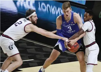  ?? GETTY IMAGES ?? GETTING DEFENSIVE: Gonzaga’s Drew Timme (2) and Joel Ayayi try to steal the ball from BYU’s Matt Haarms during Tuesday’s West Coast Conference tournament championsh­ip in Las Vegas.