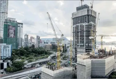  ?? PHOTO: BLOOMBERG ?? Cranes operate at a constructi­on site as work continues at a residentia­l building in Hong Kong. Annual growth in China’s property investment continues to cool while sales of earth excavators has fallen 33 percent in August from a year earlier.