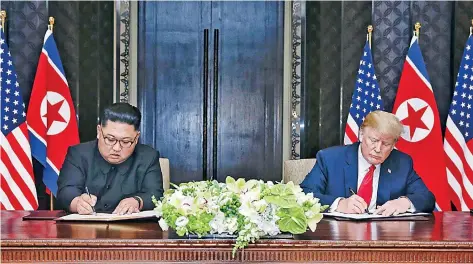  ??  ?? El líder de Corea del Norte, Kim Jong-un, y el presidente de EU, Donald Trump, al momento de firmar ayer una declaració­n conjunta tras la cumbre de Singapur.