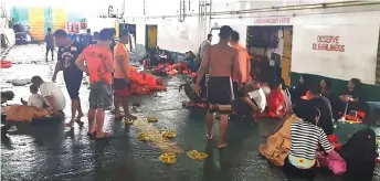  ?? — AFP photos ?? This handout photo released by the Philippine coast Guard (PCG) shows coastguard personnel attending to rescued ferry passengers from Lite Ferry after it caught fire off Dapitan, in southern island of Mindanao, as they rest on board another ferry that helped in rescue operations.