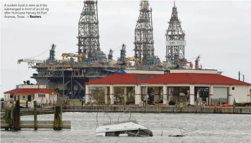  ?? — Reuters ?? A sunken boat is seen as it lies submerged in front of an oil rig after Hurricane Harvey hit Port Aransas, Texas.