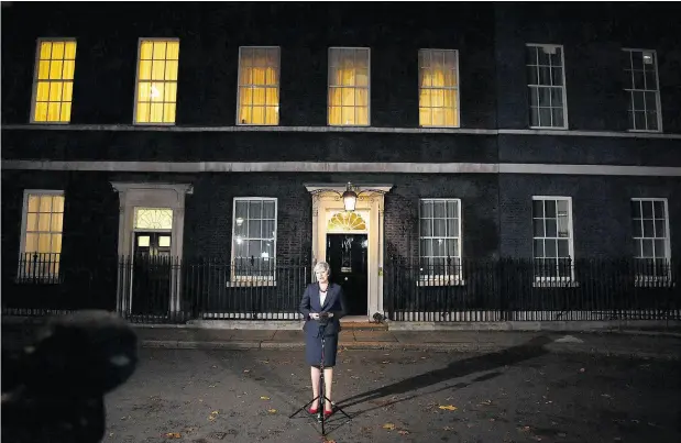  ?? BEN STANSALL / AFP / GETTY IMAGES ?? Britain’s Prime Minister Theresa May stands alone outside 10 Downing Street after defending her draft Brexit deal. On Thursday more drama unfolded as several cabinet ministers quit, pushing her government to the brink.