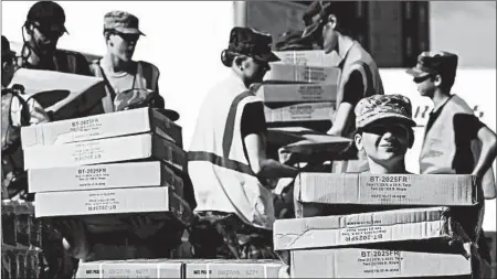  ?? CHUCK LIDDY/RALEIGH NEWS & OBSERVER ?? Boxes of tarps for victims of the storm are unloaded Tuesday in Wilmington, N.C. President Donald Trump is scheduled to visit the state on Wednesday to survey the damage.