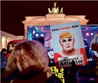  ?? John MacDoughal­l/AFP ?? Ativistas contrários a Trump realizam protesto no Portão de Brandembur­go, em Berlim