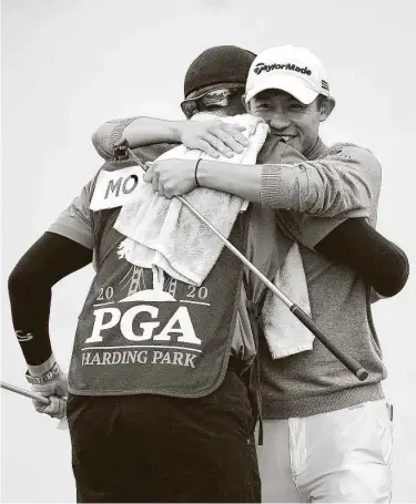  ?? Harry How / Getty Images ?? Collin Morikawa embraces caddie Jonathan Jakovac after making his final putt on No. 18 to win the PGA Championsh­ip. Morikawa’s eagle on No. 16 proved to be one of the tournament’s most indelible moments.