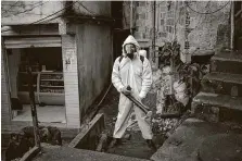  ?? Mauro Pimentel / AFP via Getty Images ?? Brazilian Thiago Firmino wears a protective suit while disinfecti­ng a favela, a poor neighborho­od, in Rio de Janeiro.