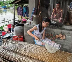  ??  ?? g Thi Bich Thien, 16, helping her mother in the family’s rice paper business.