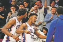  ?? MARK LENNIHAN/ASSOCIATED PRESS ?? Philadelph­ia 76ers’ Joel Embiid, left, congratula­tes teammate Jimmy Butler after he sank a game-winning three point shot against the Nets in the fourth quarter of Sunday’s game in New York. The 76ers won 127-125.