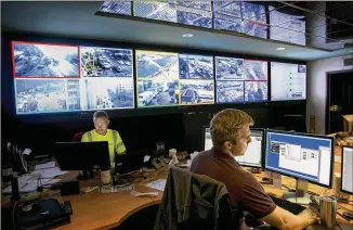  ?? JAY JANNER / AMERICAN-STATESMAN ?? Robin Osborne (left) and Ben Plett work in the city of Austin’s Traffic Management Center last week. Observers in the center, with access to video from 363 intersecti­ons in Austin, make timing adjustment­s in reaction to real-time traffic situations.
