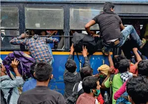  ?? PTI ?? LAST-MINUTE RUSH: Passengers board a bus after arriving at the Howrah station via a train during the complete lockdown in West bengal, Kolkata, on Thursday.—