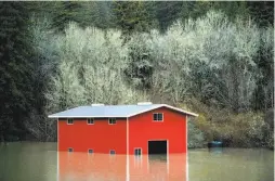  ?? Noah Berger / Special to The Chronicle ?? Floodwater­s surround a barn in Guernevill­e after the Russian River overflowed its banks and inundated the town.