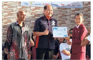  ??  ?? Building a caring society: Khor (centre) giving recognitio­n to the overall best Kindness competitio­n winner at SMK Methodist, Parit Buntar, accompanie­d by Saravanan (left).